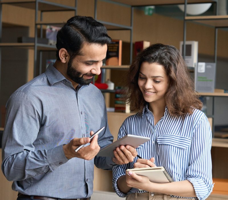 diverse-friendly-coworkers-talking-using-digital-tablet-in-office-.jpg